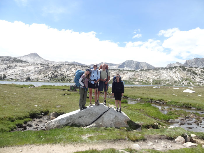 Standing on the rock with my friends, posing for a photo.